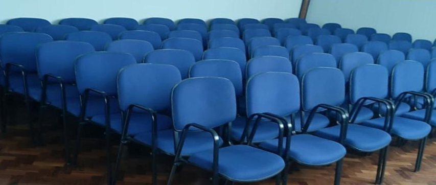 Depois: fileiras de cadeiras azuis de auditório, com assentos desbotados antes e azul vivo depois