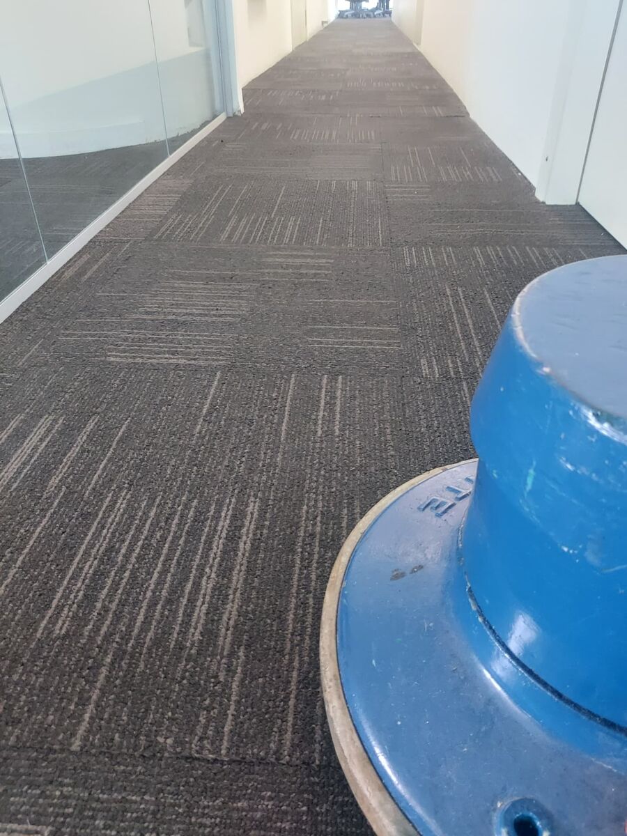 Carpete em placas de corredor corporativo durante o serviço com enceradeira.