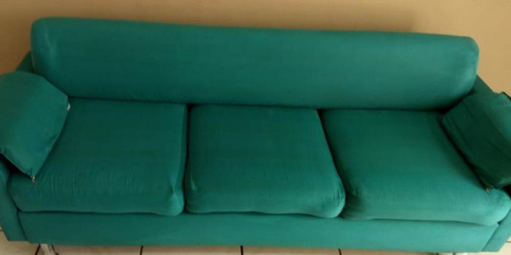 Depois: sofá verde de três lugares, com manchas escuras nos assentos antes e cor uniforme depois